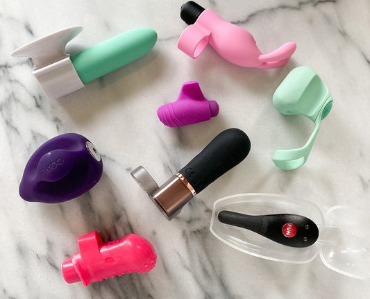 Verzameling compacte vingervibratoren en mini-vibrators in diverse kleuren en vormen op marmeren achtergrond