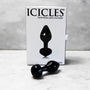 Handgeblazen glazen buttplug Icicles, zwart, met witte verpakking op marmeren ondergrond.