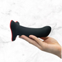Hand presenteert Fun Factory Amor dildo in zwart met rood accent aan de basis