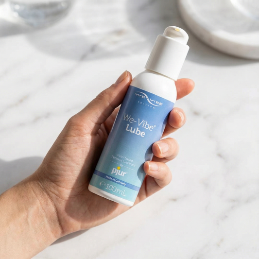 We-vibe glijmiddel fles in zijaanzicht met merkdetails zichtbaar