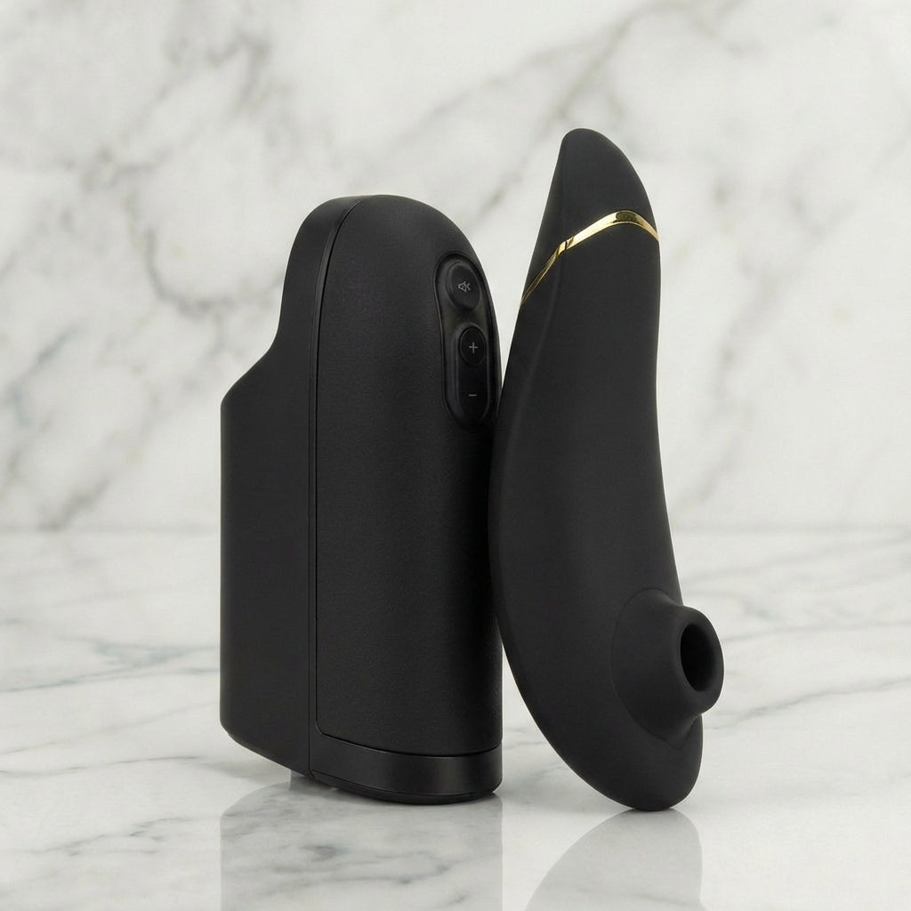 Zwarte Arcwave en Womanizer Pleasure Pair Set naast elkaar op marmeren ondergrond, gouden accenten