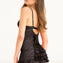 Klein zwart kanten nachtjurkje met satijnen ruches, achteraanzicht op model.