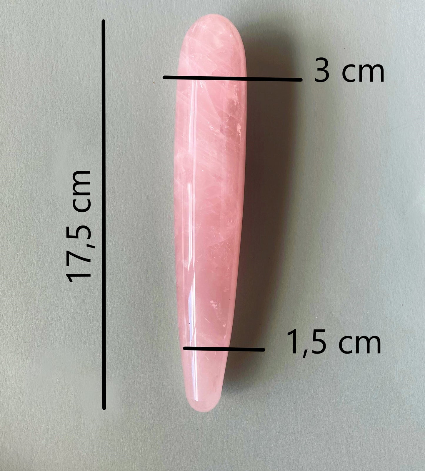 Close-up van rozenkwarts massage wand met zichtbare kristalstructuur en ergonomische vorm