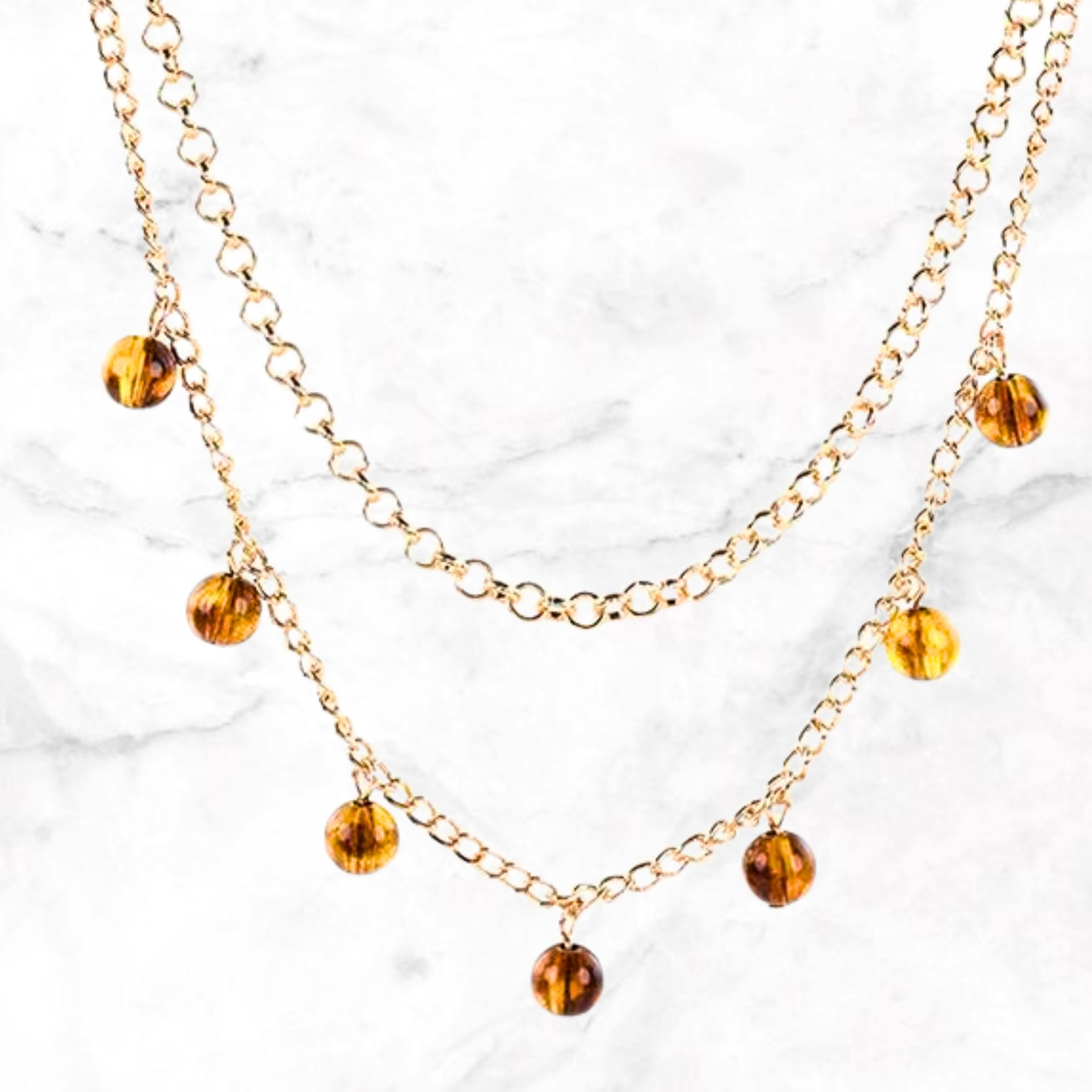 Tepelklemmetjes met goudkleurige ketting en amber steentjes