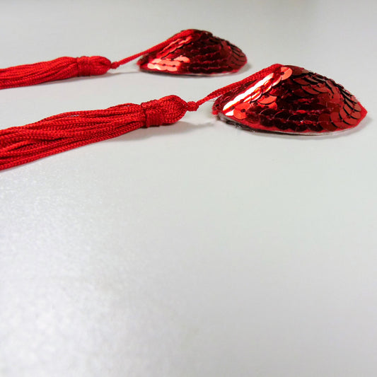 Zijaanzicht van elegante zilver-gouden tepelkwastjes met decoratieve details