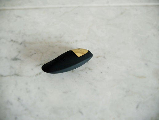 Sfeervolle presentatie van paarse Spot vibrator op zachte ondergrond met warme verlichting