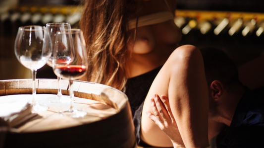 Intieme scène in wijnkelder met vrouw naast wijnglazen op een vat, warme sfeerverlichting, XConfessions Vol. 6